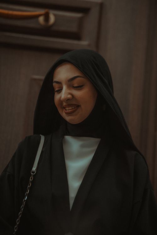 Free Young woman in black headscarf smiling, exuding elegance and style. Stock Photo