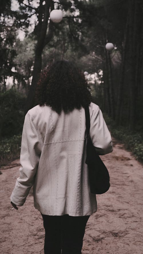 Back View of Woman Walking on Footpath