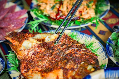 Close-up of a Person Grabbing Food from the Table with Chopsticks