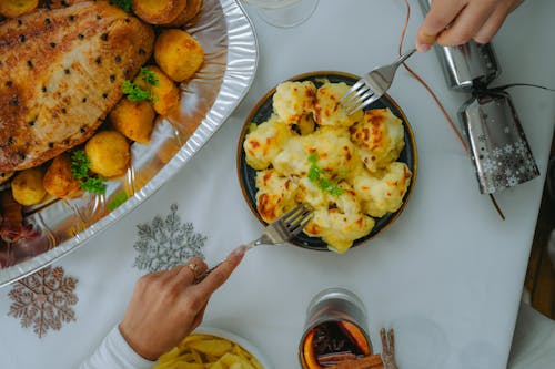 Hands Holding Forks over Bowl with Food