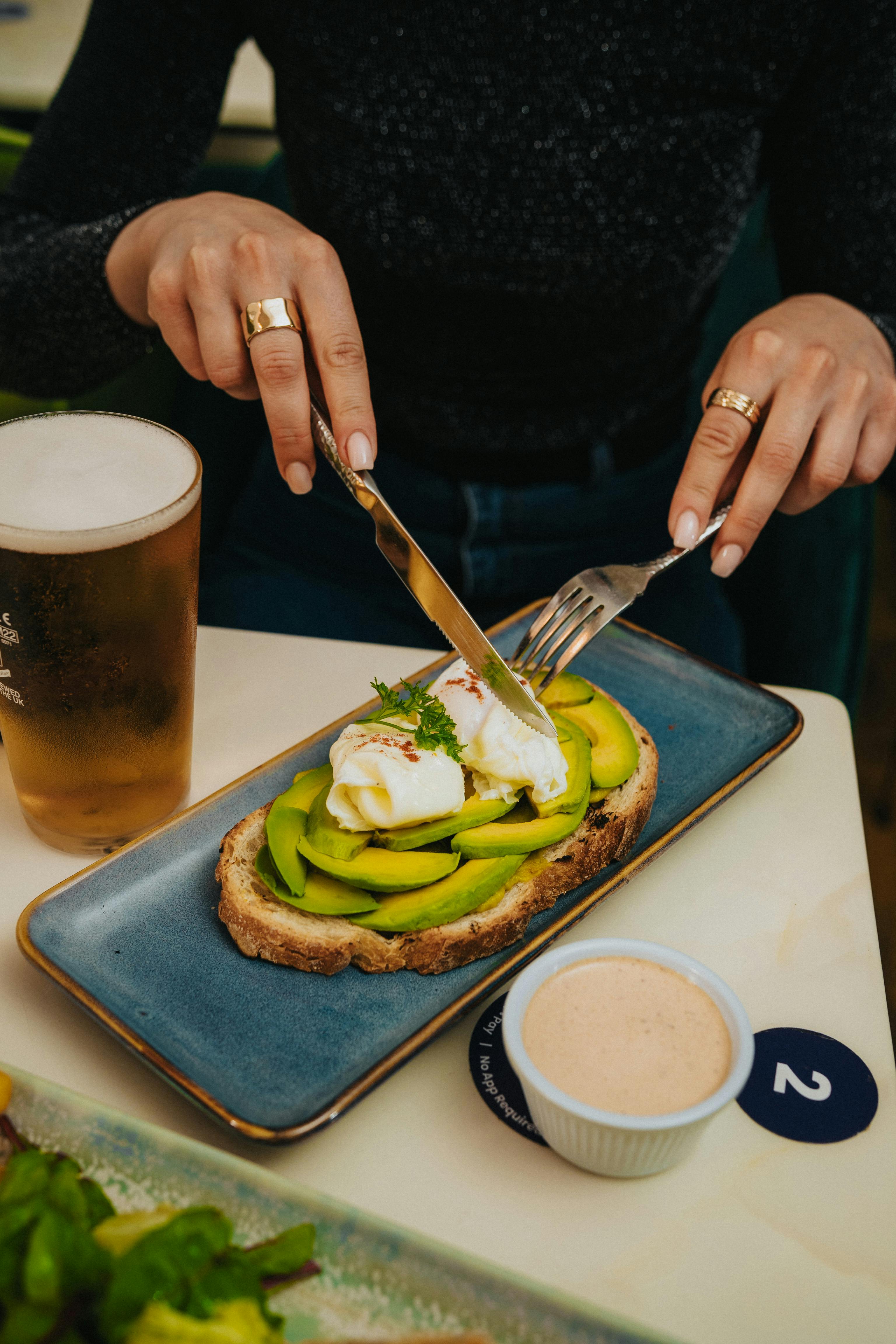 Delicious avocado toast and poached egg paired with a refreshing beer in an English cafe.