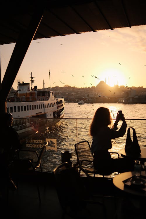 Silhouettes of People Sitting in a Cafe on a Terrace with the View of the Bosphorus Strait and Istanbul Skyline 