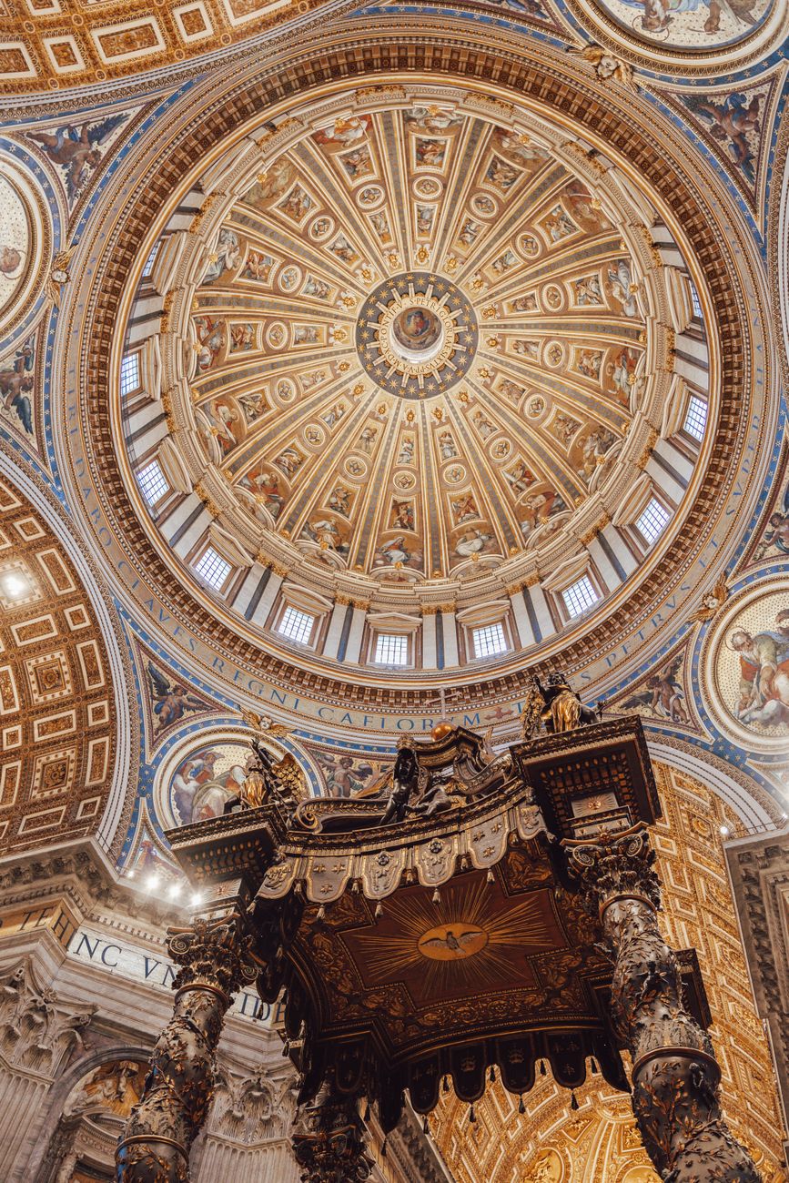 Breathtaking uitzicht op de versierde koepel binnen de Sint-Pietersbasiliek in Rome, met de nadruk op de ingewikkelde details.