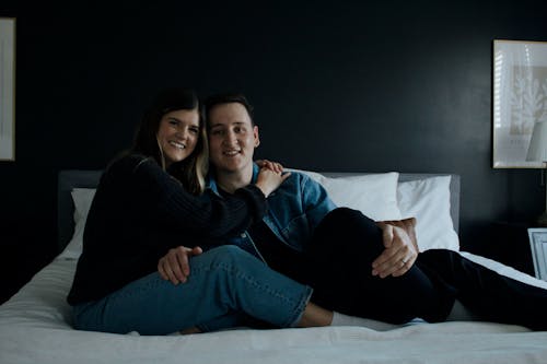 Free A Couple Sitting on the Bed and Hugging  Stock Photo