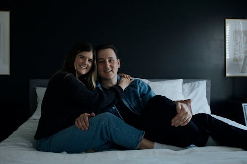 Free A Couple Sitting on the Bed and Hugging  Stock Photo