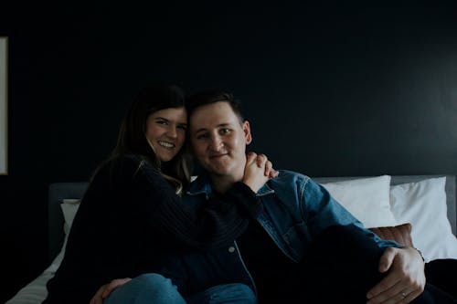 Free A Couple Sitting on the Bed and Hugging  Stock Photo