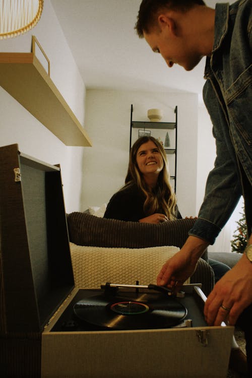 Smiling Woman Sitting and Man Standing by Gramophone