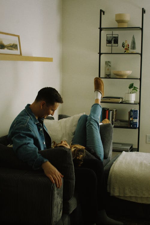 Free Couple Sitting and Lying Down on Couch Stock Photo