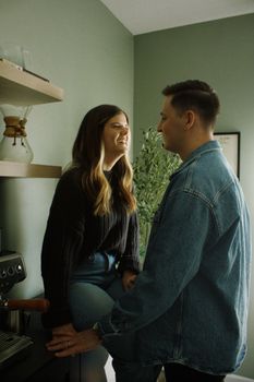 A couple smiling in a home kitchen, creating a warm and cozy atmosphere.