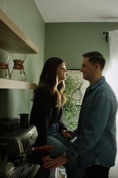 A loving couple shares a tender moment in their cozy kitchen setting.