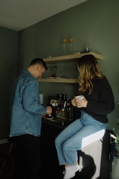 Young couple enjoying a casual morning making coffee in a cozy home kitchen.