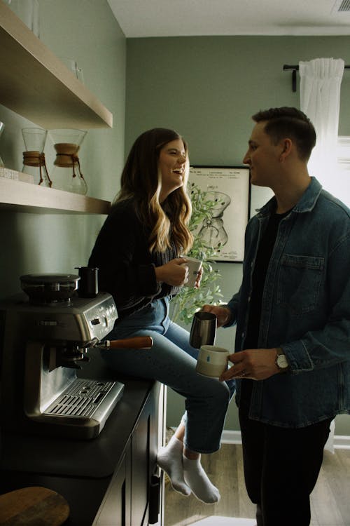 Cheerful Couple by Coffee Machine
