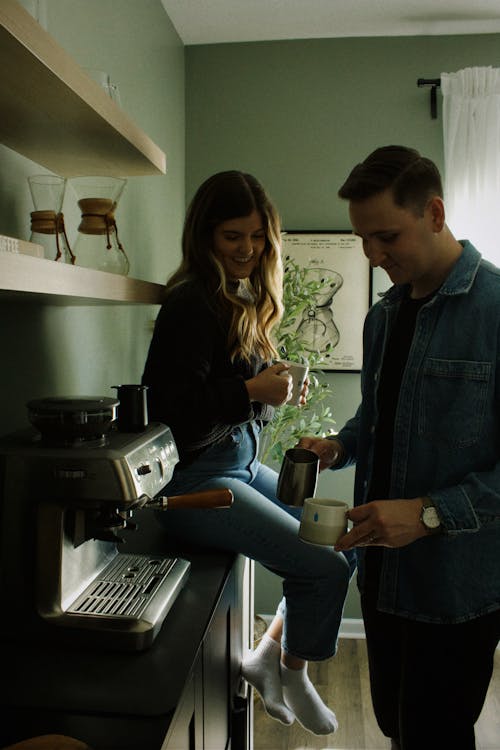 Man and Woman by Coffee Machine Preparing Coffee