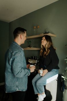 A man and a woman share a friendly conversation over coffee in a cozy indoor setting.