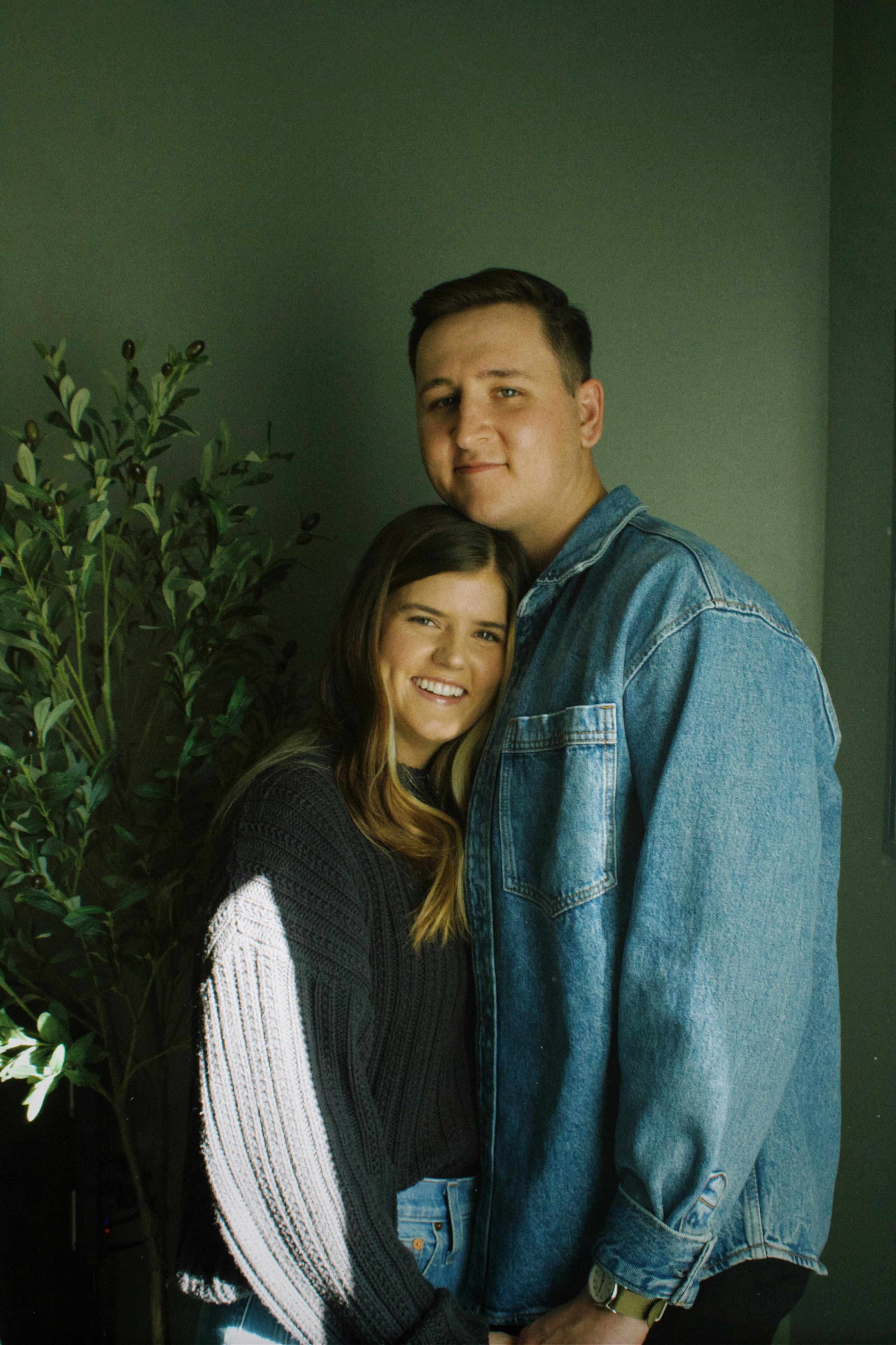 A young couple sharing a close embrace indoors, radiating happiness.