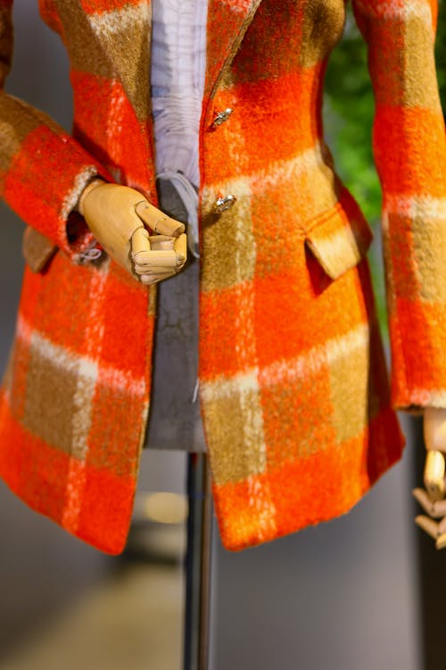 A mannequin wearing a orange plaid jacket
