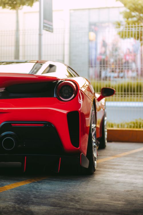 Free Capture of a sleek red sports car parked in a city environment, exuding luxury and style. Stock Photo