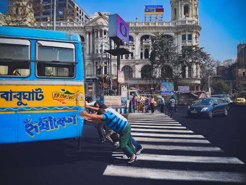 People Pushing Bus on Street in Kolkata