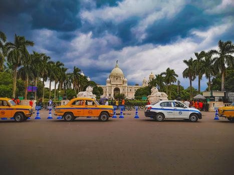 Vibrant city scene with taxis and Victoria Memorial in Kolkata, India.