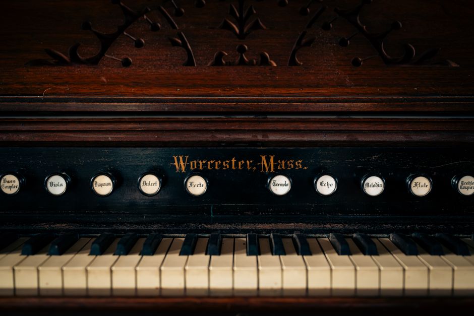 Close-up of a vintage piano with organ buttons, showcasing intricate design and history.