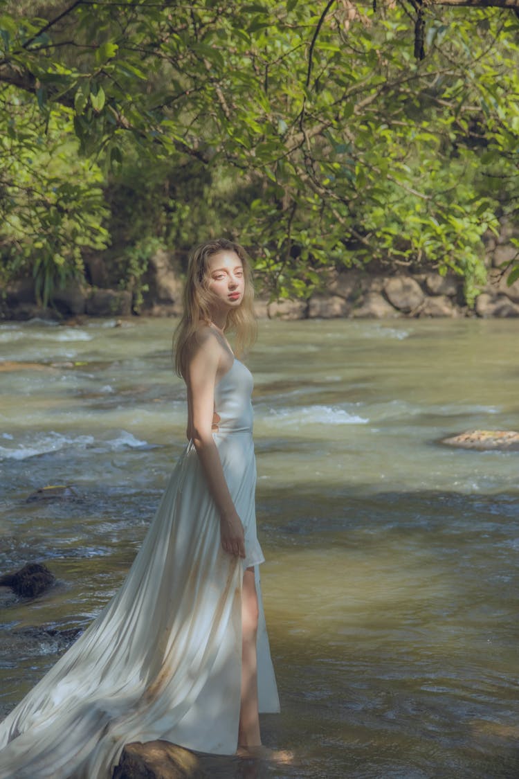 Blonde In Long White Dress Posing In River