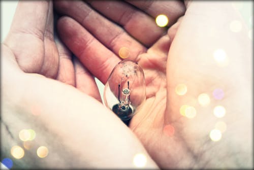 Free Centered Clear Bulb on Human Hand Stock Photo