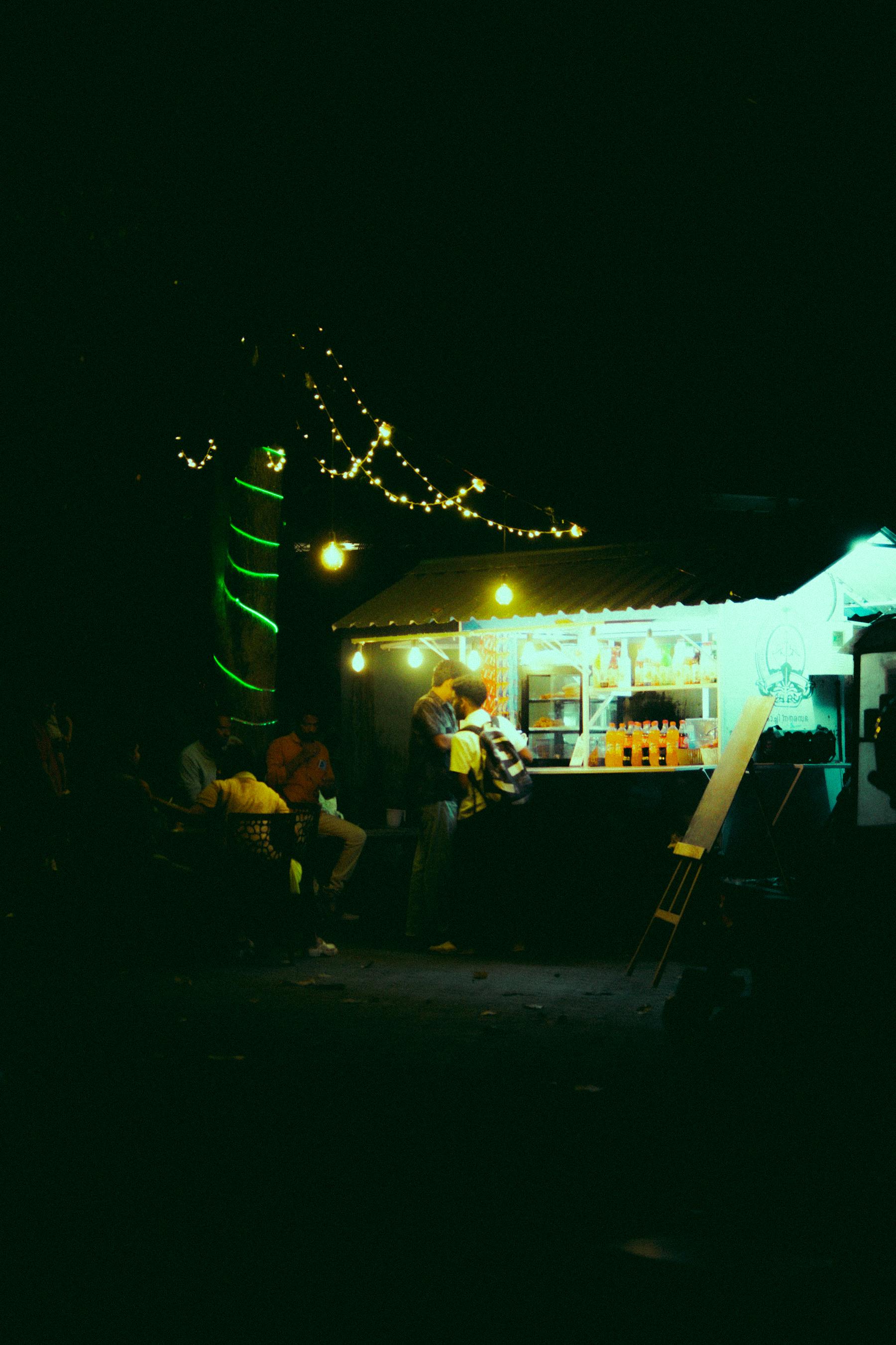 people by food stand at night