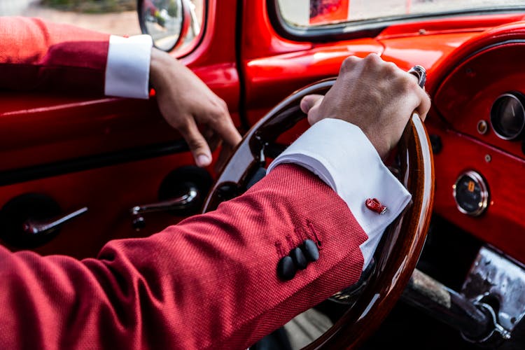 Man In A Suit Driving A Vintage Car