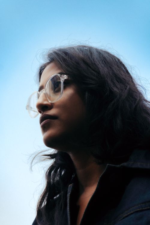 Free Portrait of a young woman with eyeglasses against a clear sky background. Stock Photo