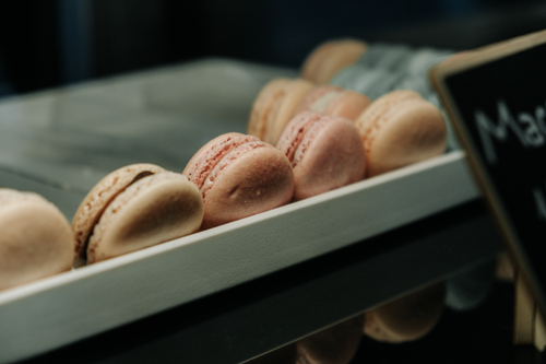 Free A close-up of various macarons on display in a bakery, showcasing their vibrant colors and textures. Stock Photo