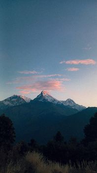 A stunning view of snow-capped mountains silhouetted against a vibrant sunset sky.