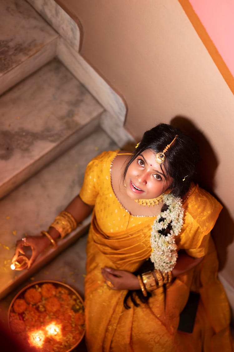 Woman In Yellow, Traditional Dress Sitting On Stairs