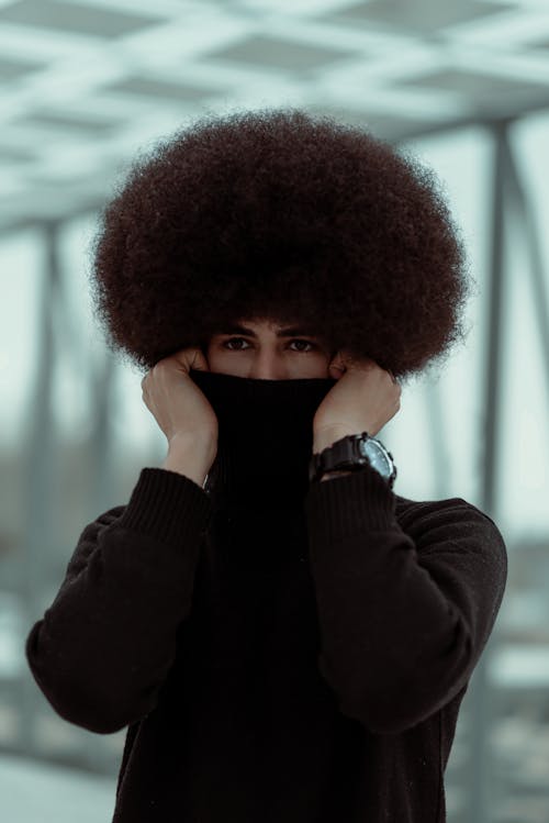 Man with Curly Hair Posing in Turtleneck Sweater