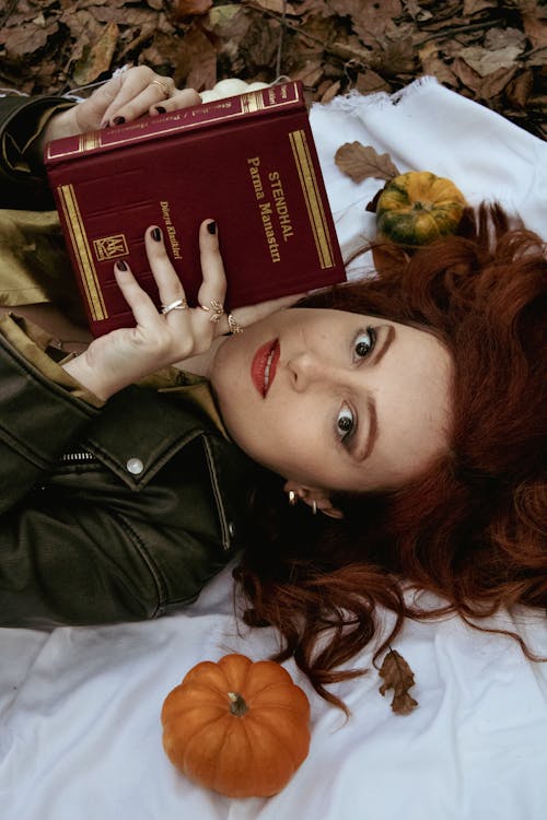 Portrait of Woman Lying on Blanket Holding Book