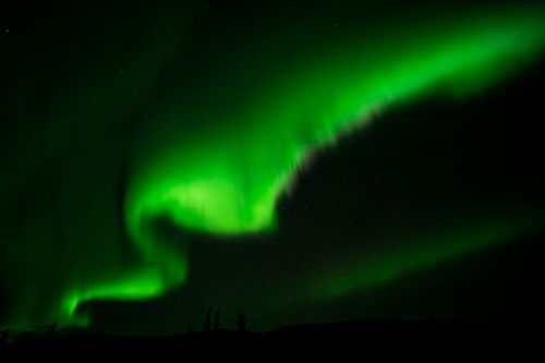 Free Capture of the dazzling green aurora borealis dancing in the starry night sky over Nelchina, Alaska. Stock Photo