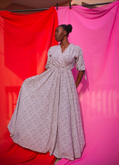 Model in a Long White Wrapover Dress with Polka Dots