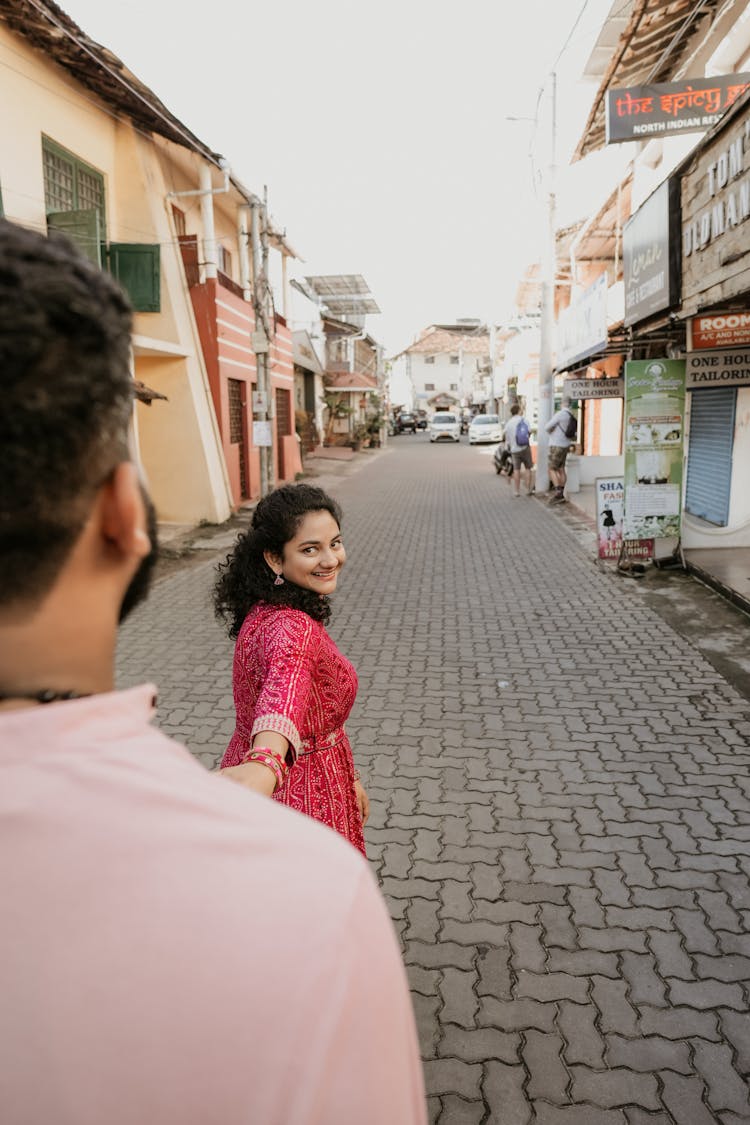 Young Brunette Woman Leading A Man By His Hand