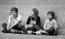 A group of people sitting on the ground with skateboards