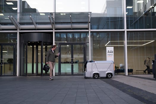 A man encounters a delivery robot outside a modern glass building.