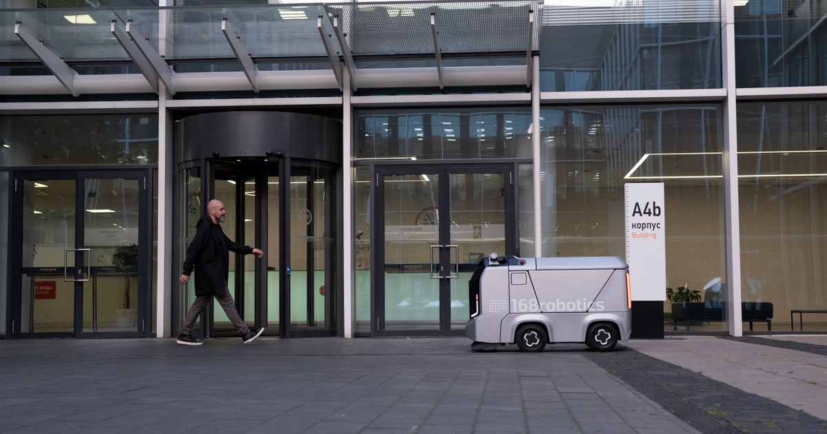 Autonomer Reinigungsroboter vor einem Bürogebäude, Symbol für Reinigungsroboter in der Gebäudereinigung