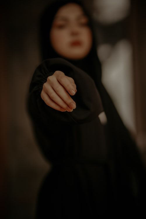 Free Focus on outstretched hand of a woman in a black dress, moody atmosphere. Stock Photo