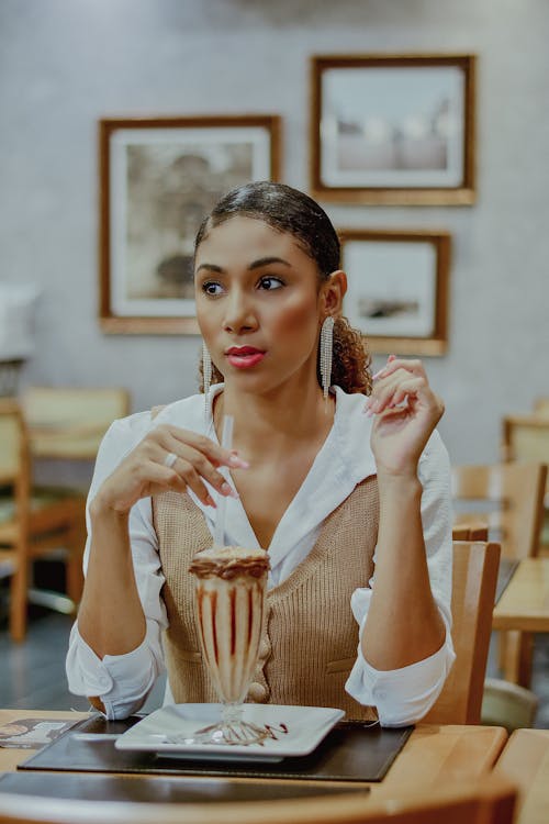 Woman Drinking Iced Coffee in a Restaurant 
