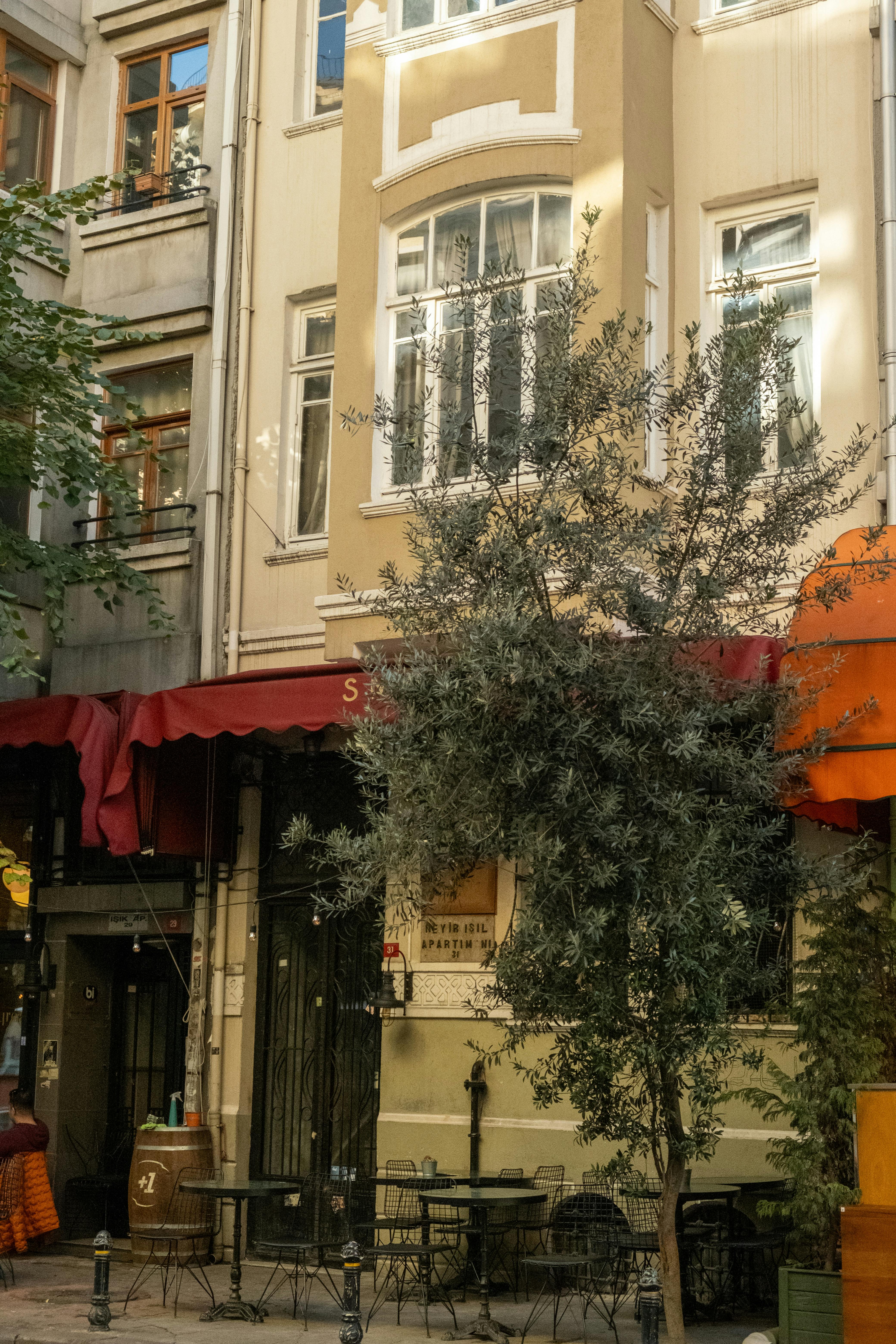 A picturesque view of a cafe on a quaint street in Istanbul, Türkiye, with a townhouse backdrop.
