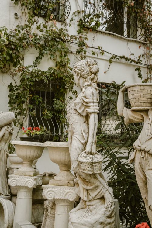 Free A classical baroque sculpture surrounded by foliage in an Istanbul garden setting, accentuating elegance. Stock Photo