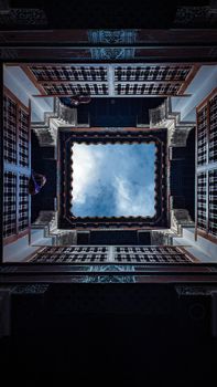 View of a traditional Marrakesh courtyard ceiling with sky visible through open square space.