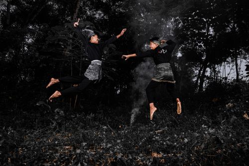 Free Two men engaged in a dramatic martial arts duel in a forest setting, showcasing samurai costumes. Stock Photo