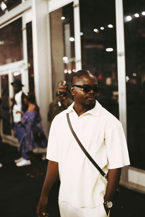 Free A stylish man wearing sunglasses and a white shirt at an outdoor event. Stock Photo