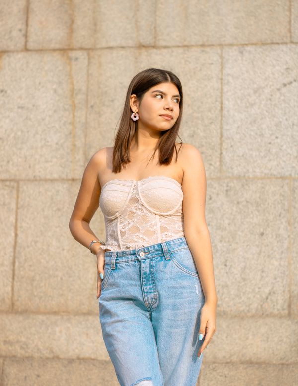 Woman in cream corset top with jeans