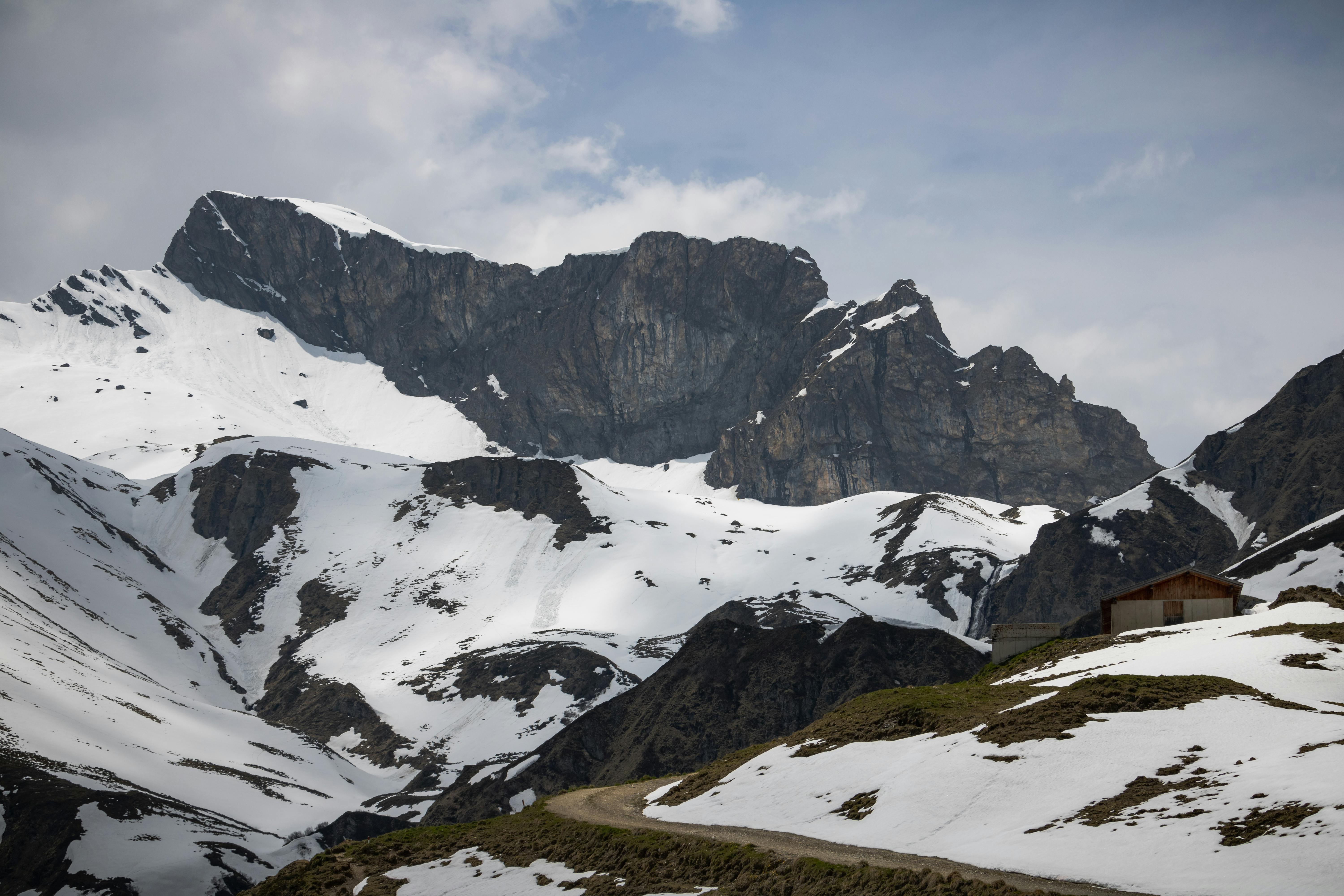 a mountain road with snow covered mountains in the background