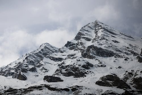 A snow covered mountain with a cloudy sky